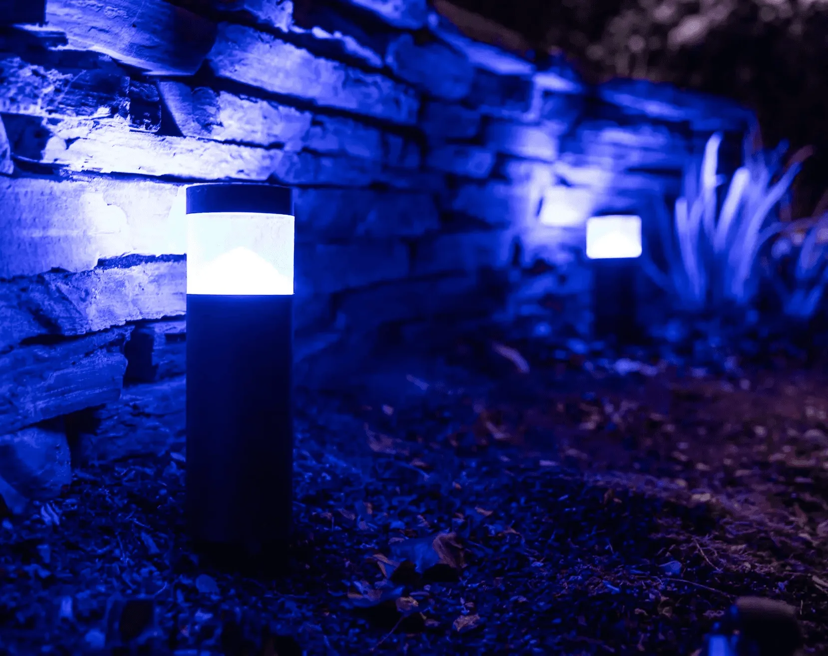 Happy's cylinder light in a flower bed