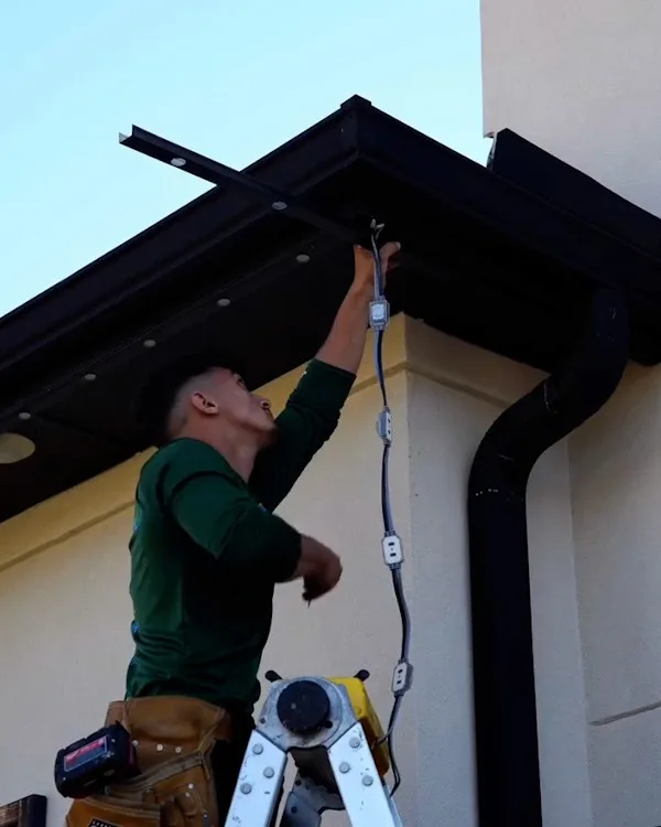 Happy's installer fitting track under an eave